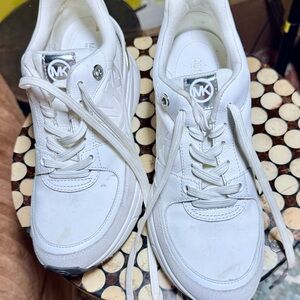 Michael Kors White Leather MK Emblem Sneakers with a small wedge in the back.